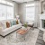 Bright open concept living room with wood-style flooring, large windows, and direct access to private patio at Westmount at Mason Creek.